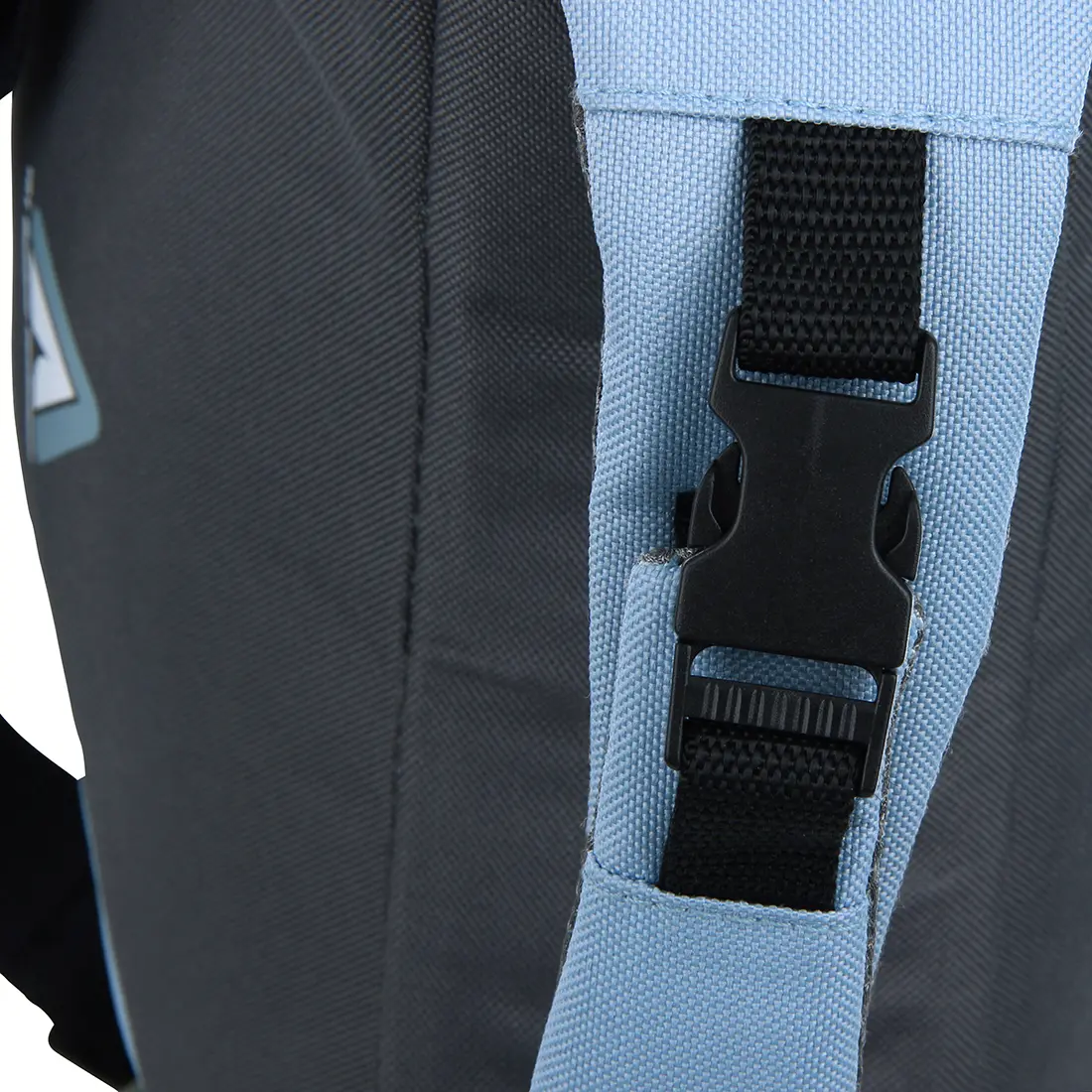 Ein Detailbild eines Rucksacks, bei dem die schwarze Schnalle einer blauen Riemenlasche im Mittelpunkt steht, umgeben von dunkelgrauem und hellblauem Stoffmaterial.